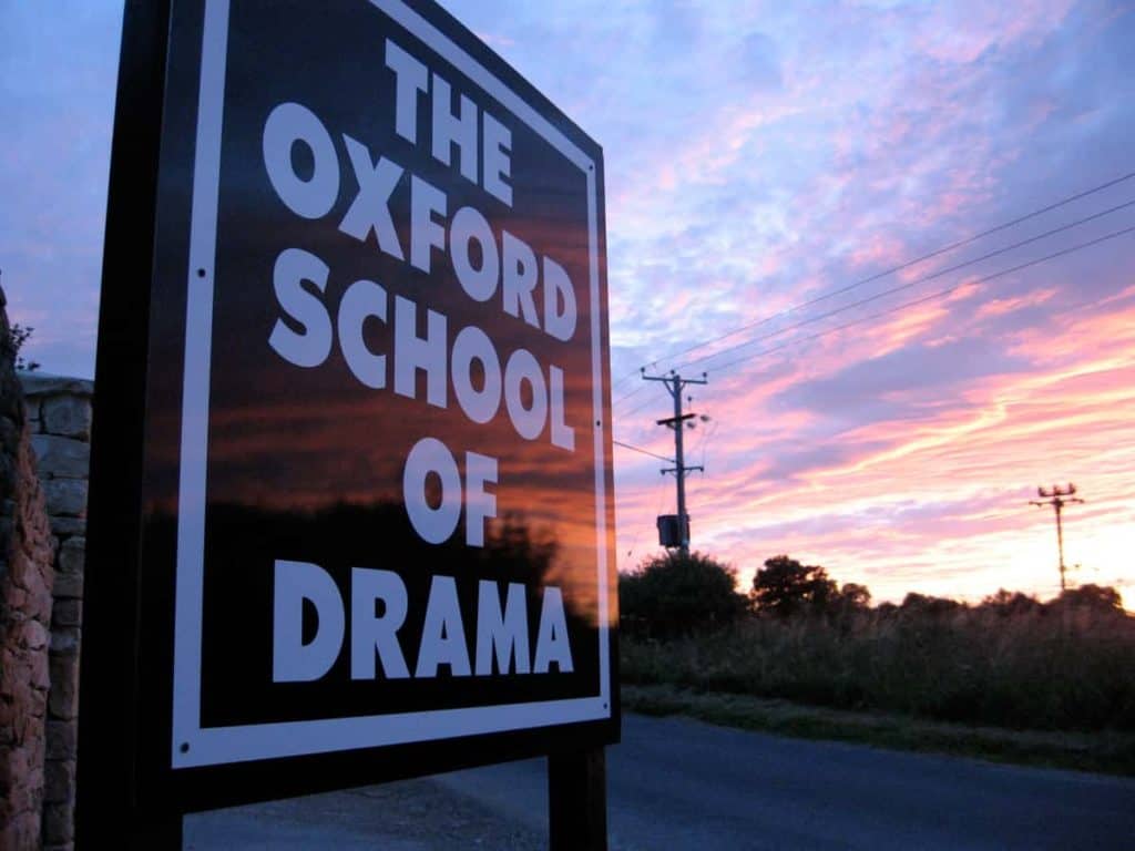 Sign with The Oxford School of Drama in white bold capitalised Font on a dark background